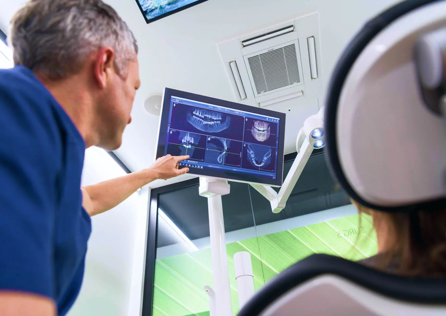 Dentist and patient examine dental xray